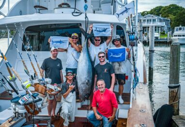 Capt. Harry Garrecht and his crew posing with a catch on deck.