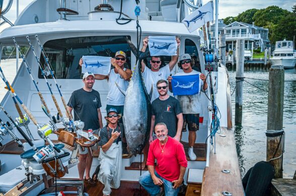 Capt. Harry Garrecht and his crew posing with a catch on deck.