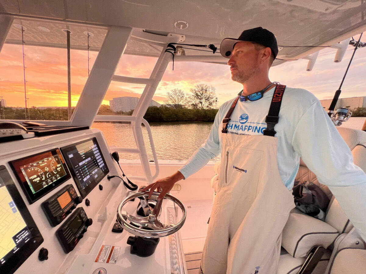 SiriusXM - Man stands at the wheel of a boat looking ahead while navigating waters