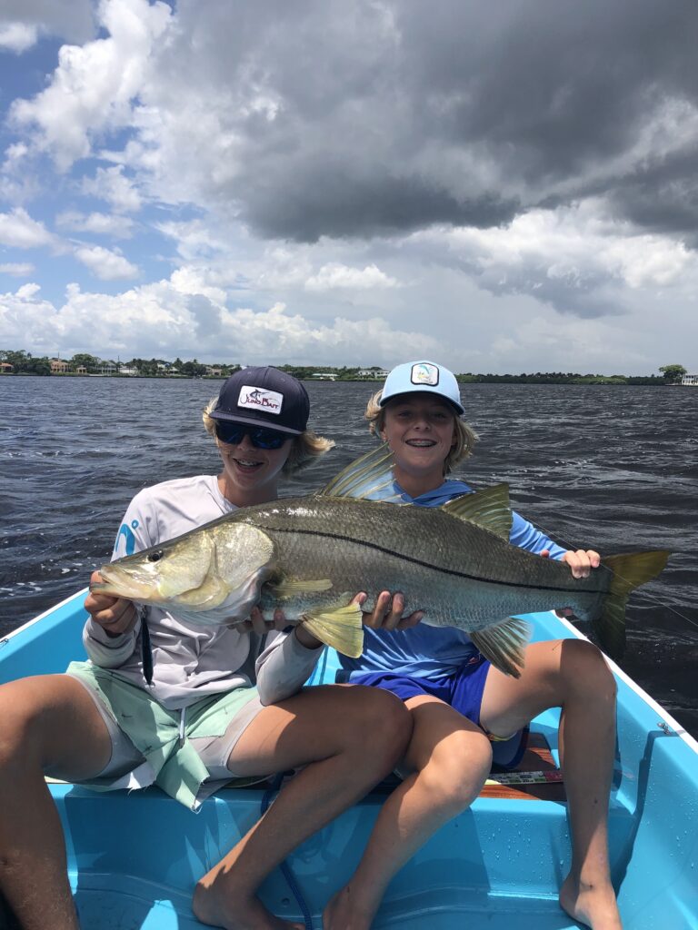Kids holding a snook fish