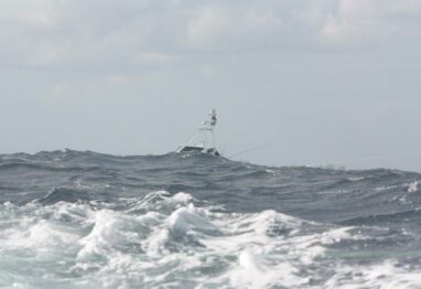 Boat barely visible between large rollers