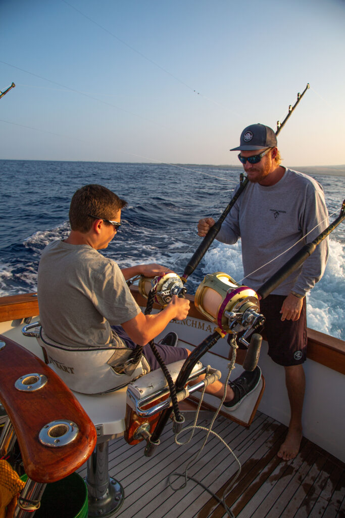 Explaing how to reel in a marlin to an angler in the fighting chair