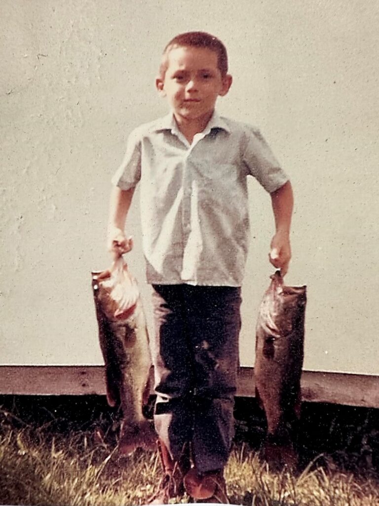 Ray Rosher as a boy holding bass