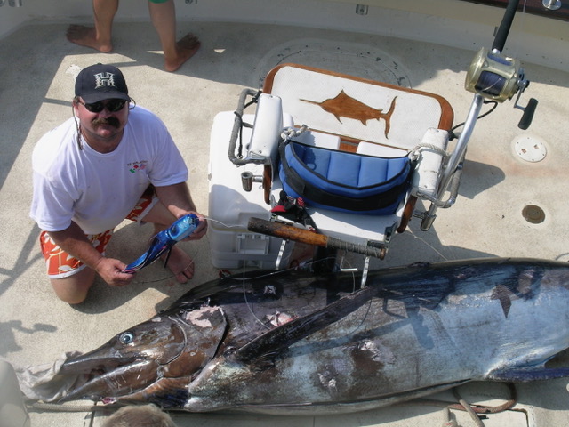 Steve Coggin sits with the 595-pound marlin he caught on his Tado lure in the 2009 Kona Firecracker Fishing Tournament