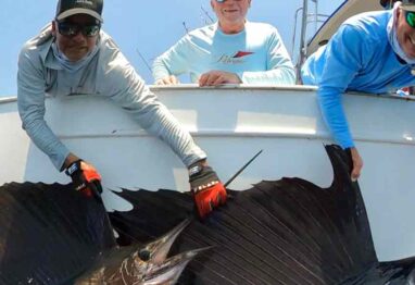 Guatemala billfish fishing and an image with 2 guys holding up sailfish at the side of the boat