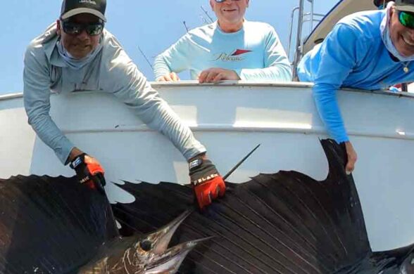 Guatemala billfish fishing and an image with 2 guys holding up sailfish at the side of the boat