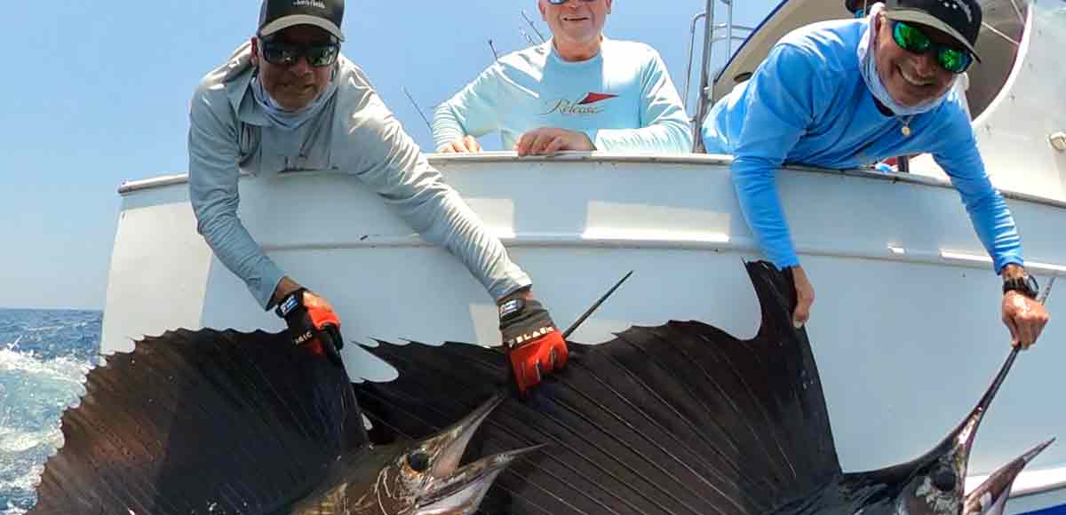 Guatemala billfish fishing and an image with 2 guys holding up sailfish at the side of the boat