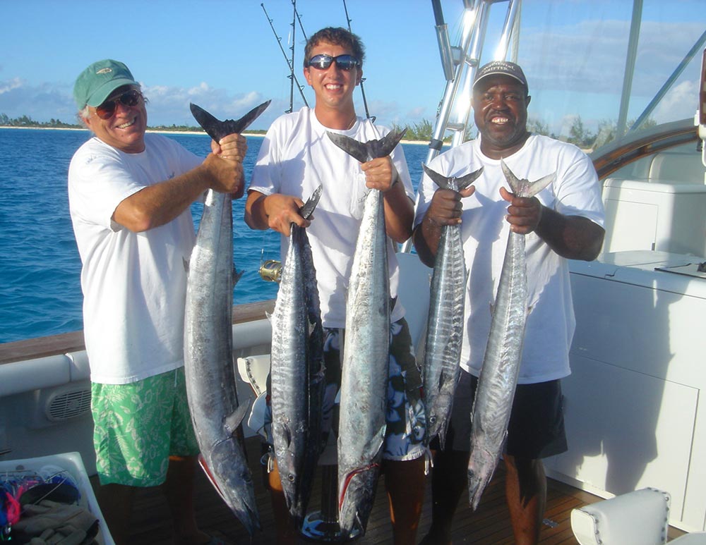 Jimmy buffett and 2 other guys holding up a total of 5 kingfish