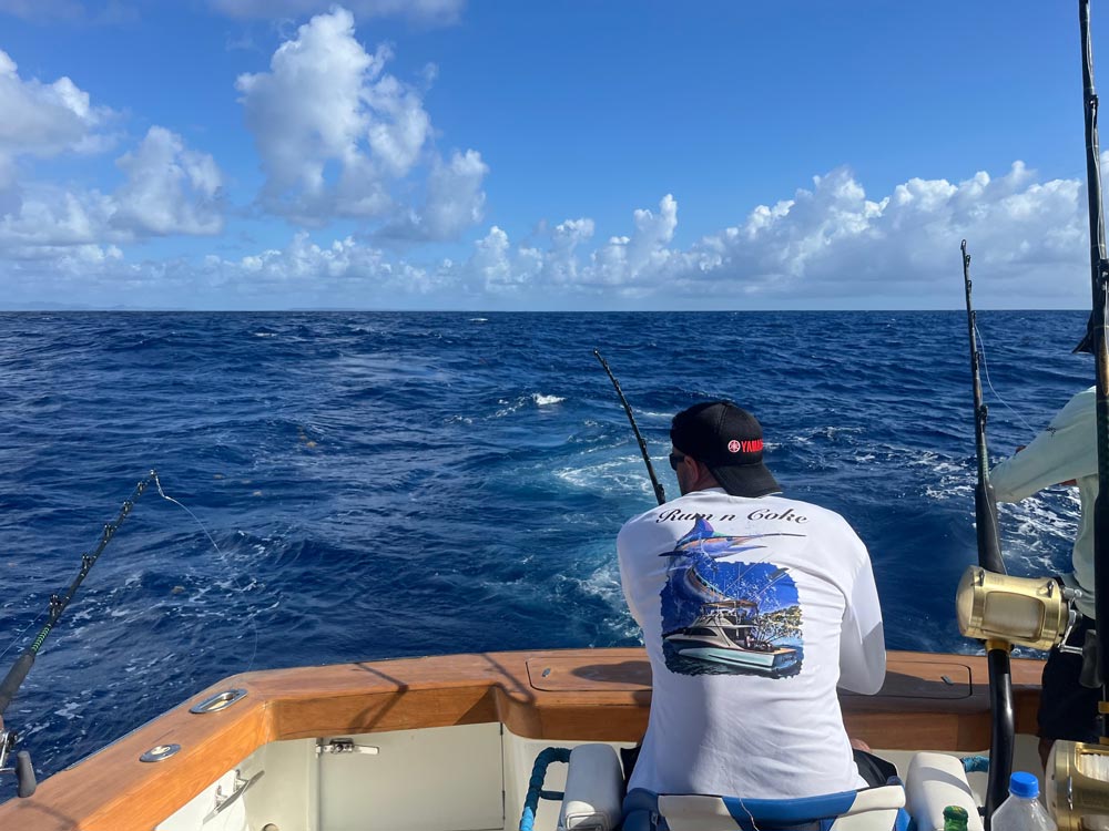 man fishing off back of boat