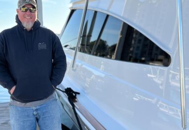 chase lake standiing on a dock next to a viking boat