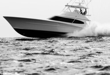 grey scale image with a sportfishing boat running on the ocean