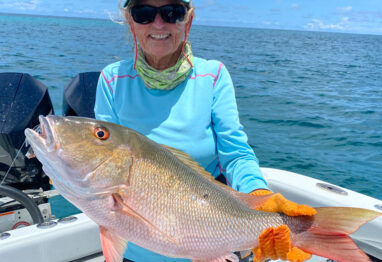 A nice image of a lady holding a big mutton as the featured image for the Mutton Snapper fishing Tips article