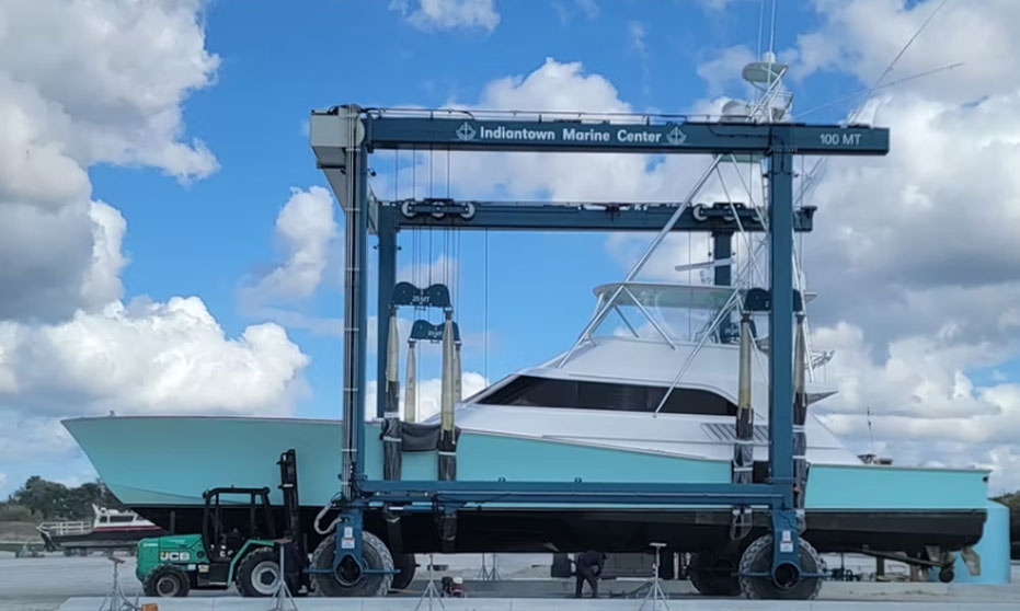a aqua colored boat in a Indiantown Marine Center boat lift