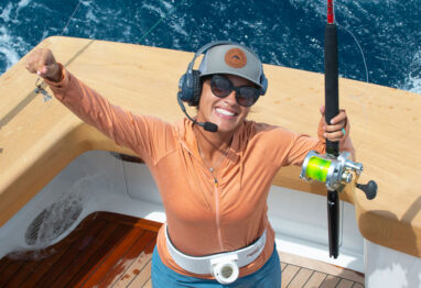 a lady angler holding up a rod and missing bait on her hook