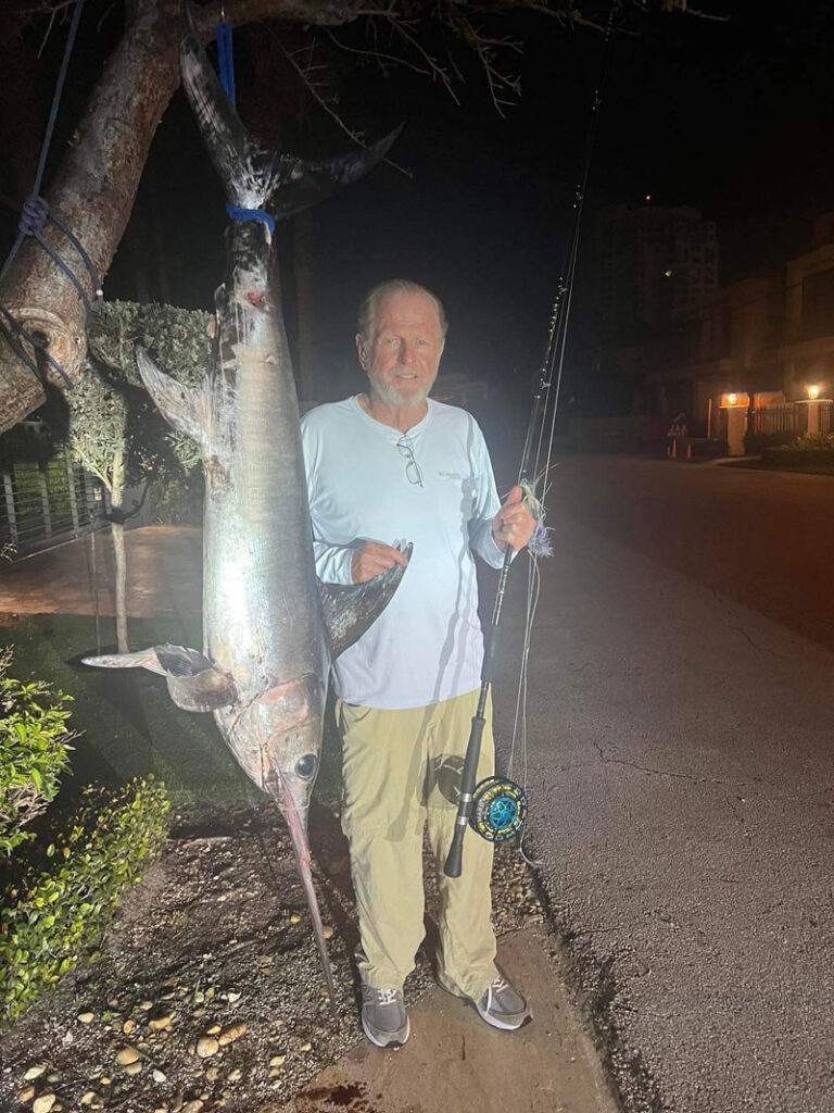 Roy Cronacher standing next to a swordfish fly fishing capture