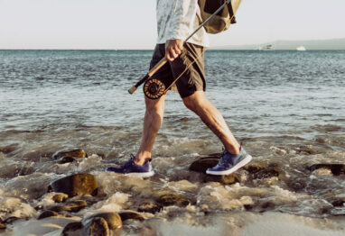 a guy walking with CrossCurrent Boat Shoes on rocks