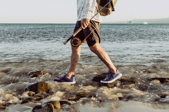 a guy walking with CrossCurrent Boat Shoes on rocks