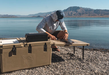 pacbak p88-mk cooler brown in color with a guy filleting fish next to it