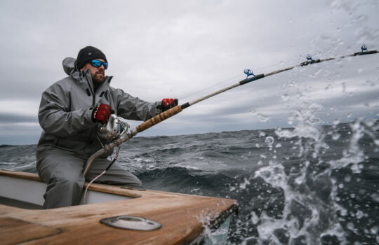 a guy fishing wearing pelagic foul weather gear offshore fishing