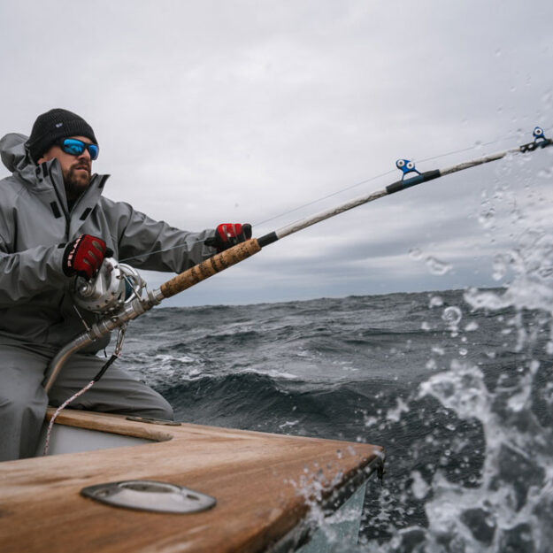 a guy fishing wearing pelagic foul weather gear offshore fishing