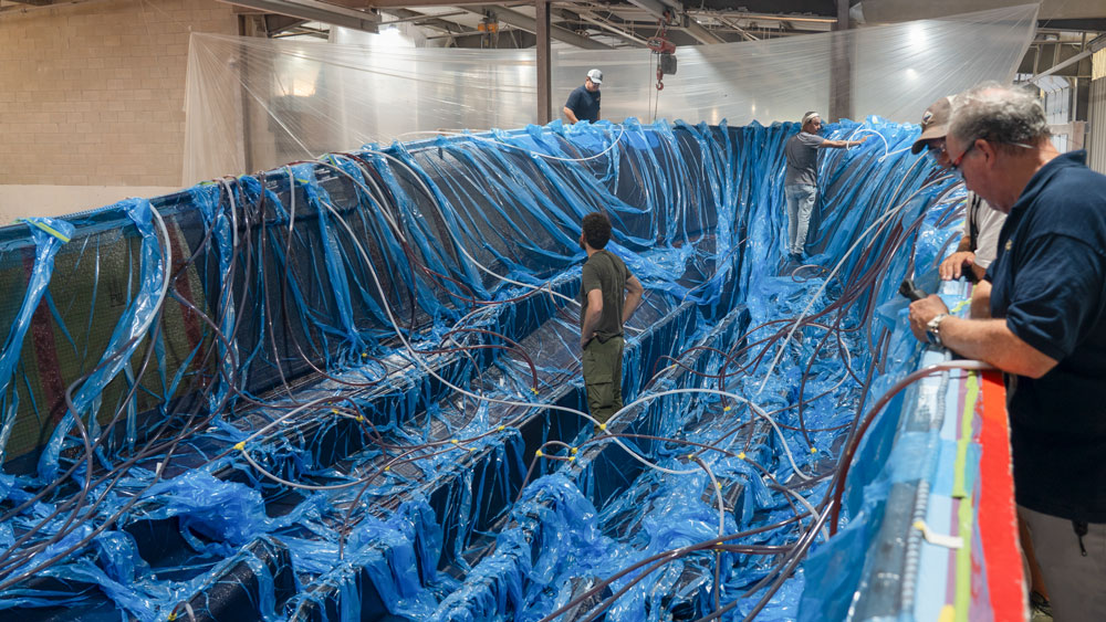blue plastic ona boat hull getting vacuum bagged for resin infusion