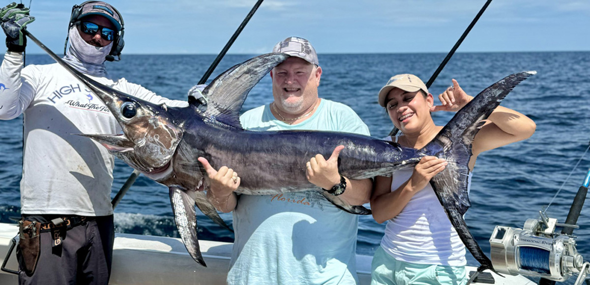 3 people holding up a nice swordfish on the ocean