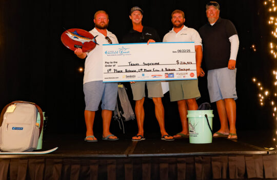 team supreme with a winning tournament check during the award ceremony