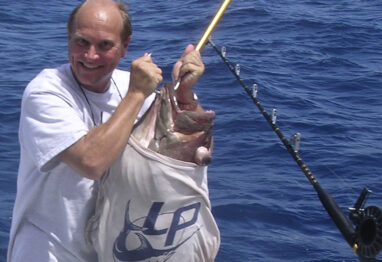 Lindgren Pitman's Peter Lindgren holding a big grouper with a LP t-shirt on the fish