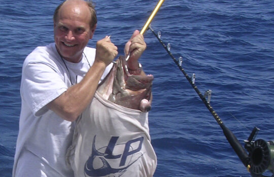 Lindgren Pitman's Peter Lindgren holding a big grouper with a LP t-shirt on the fish
