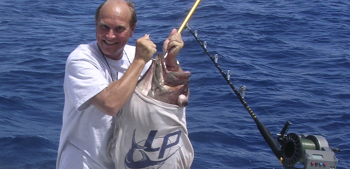 Lindgren Pitman's Peter Lindgren holding a big grouper with a LP t-shirt on the fish