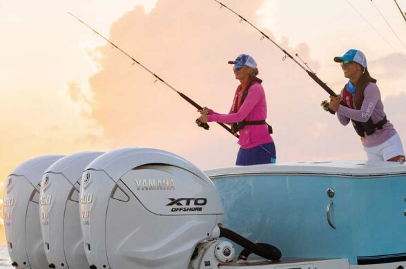 2 ladies fishing with a pink cloudy sky in the background