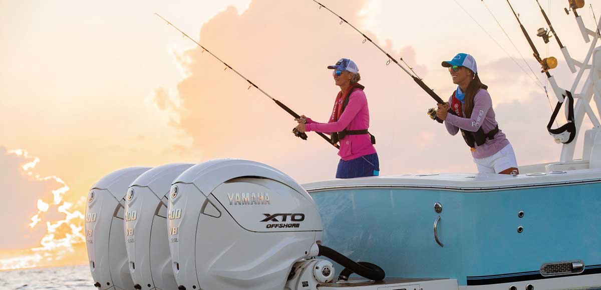 2 ladies fishing with a pink cloudy sky in the background