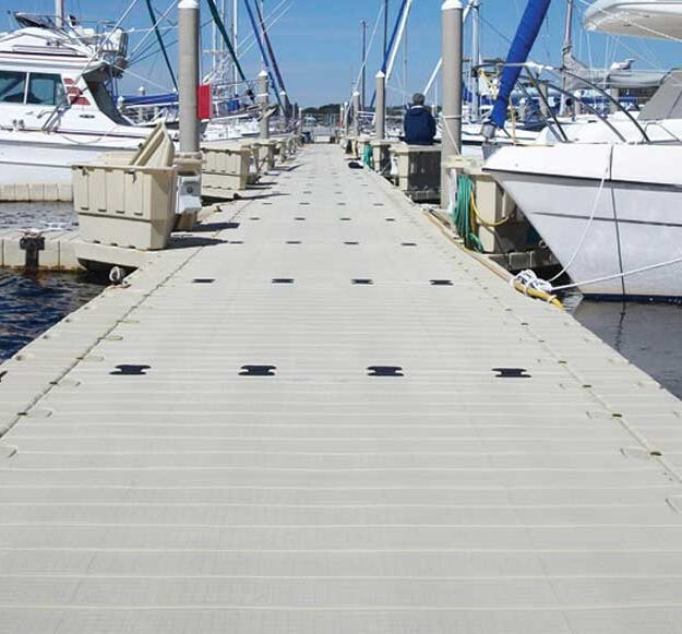 a long floating dock with boats tied to both sides