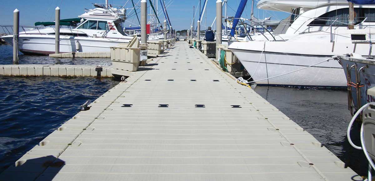 a long floating dock with boats tied to both sides