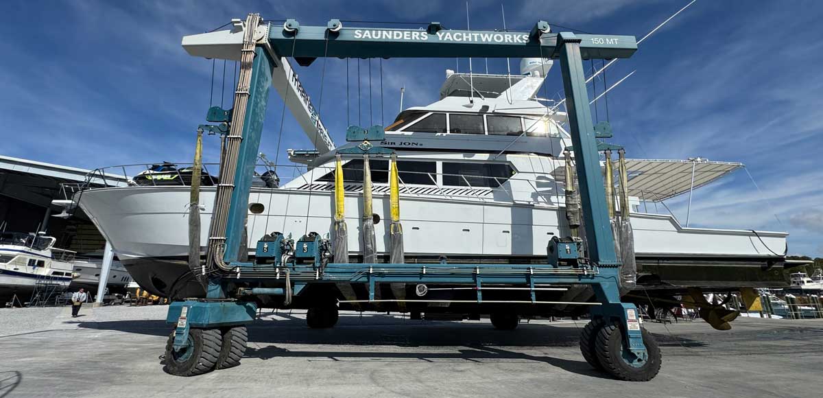 depicts a big sportfishing boat in a travel lift for the article REFIT GUIDE: WHEN DOES MAINTENANCE BECOME A REFIT?