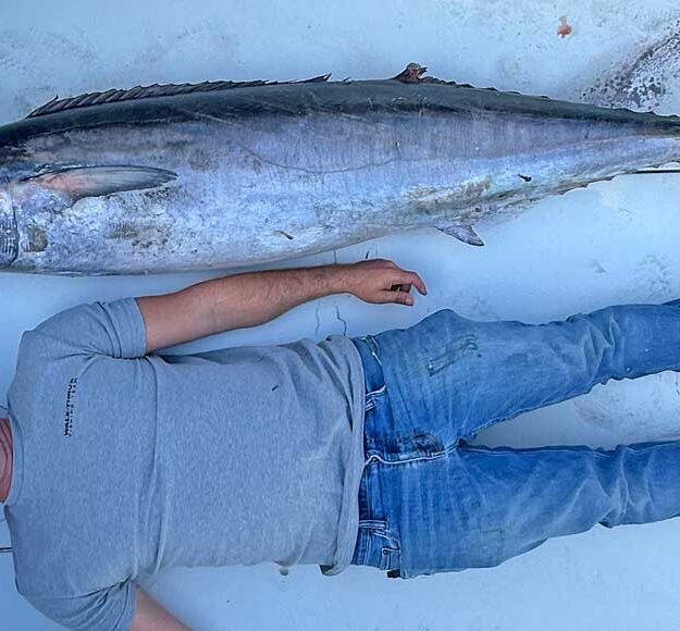 Northeast Florida Wahoo Fishing has emerged as a place for giant wahoo like this one with a man lying next to it