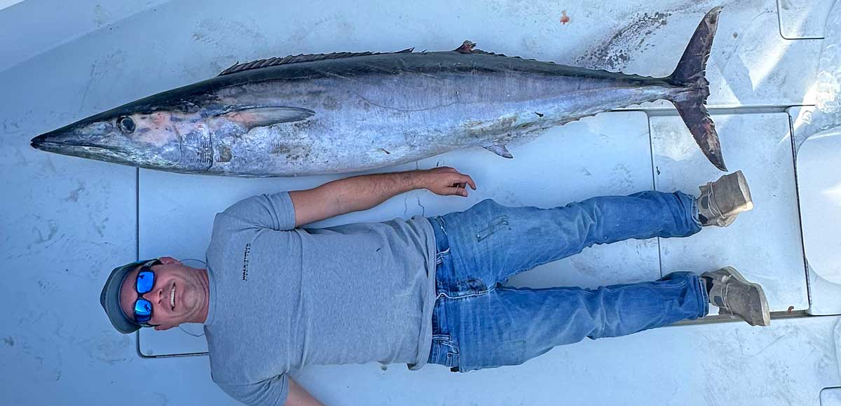Northeast Florida Wahoo Fishing has emerged as a place for giant wahoo like this one with a man lying next to it