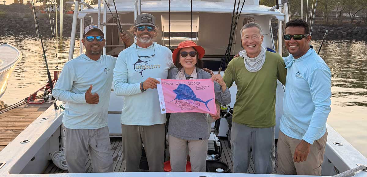 Helen Tang Sets New Sailfish Fly Record with 19 Releases holding thepink flag with the crew in this image