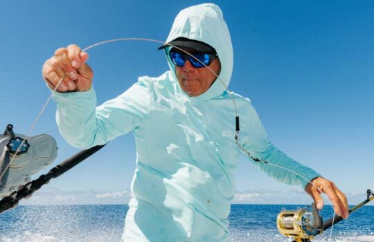 AFTCO’s Air-O Mesh Performance Collection on a guy holding a fishing line