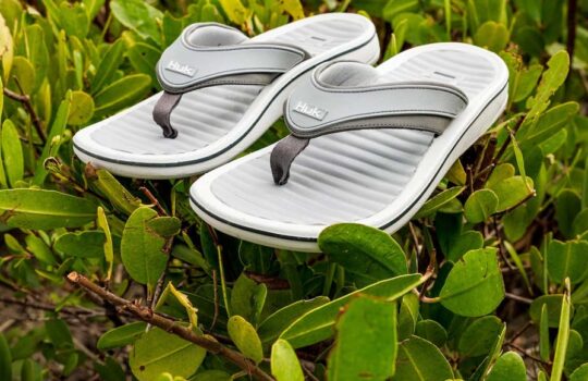 Huk Launches Rogue Island Flip Flop sitting on a green bush
