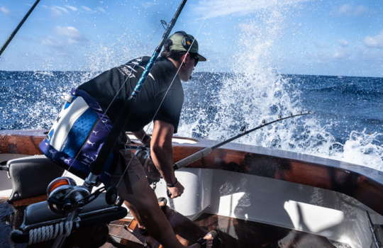 angler fishgting a blue marlin in rough seas