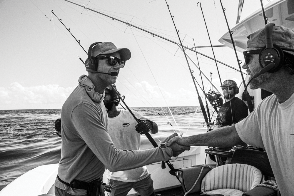 two guys shaking hands on a boat