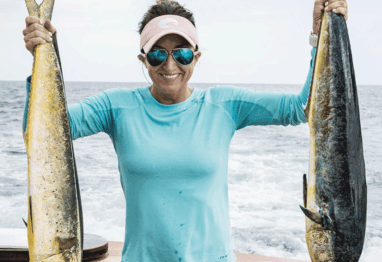 Carly Hysell from Garmin holding up two mahi