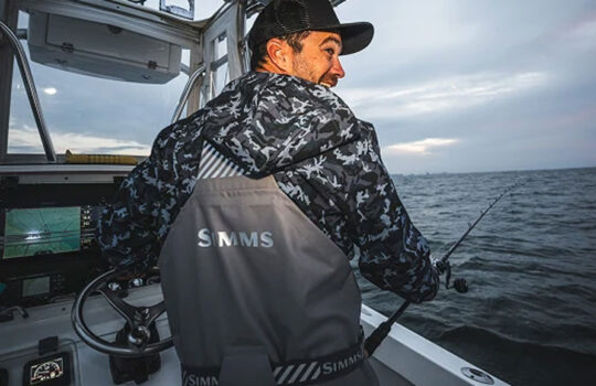 a captain wearing Simms Rip Line Pro on grey