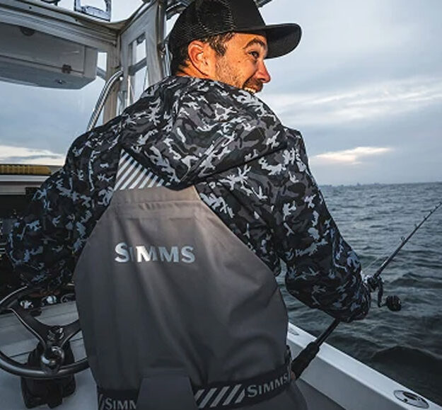 a captain wearing Simms Rip Line Pro on grey