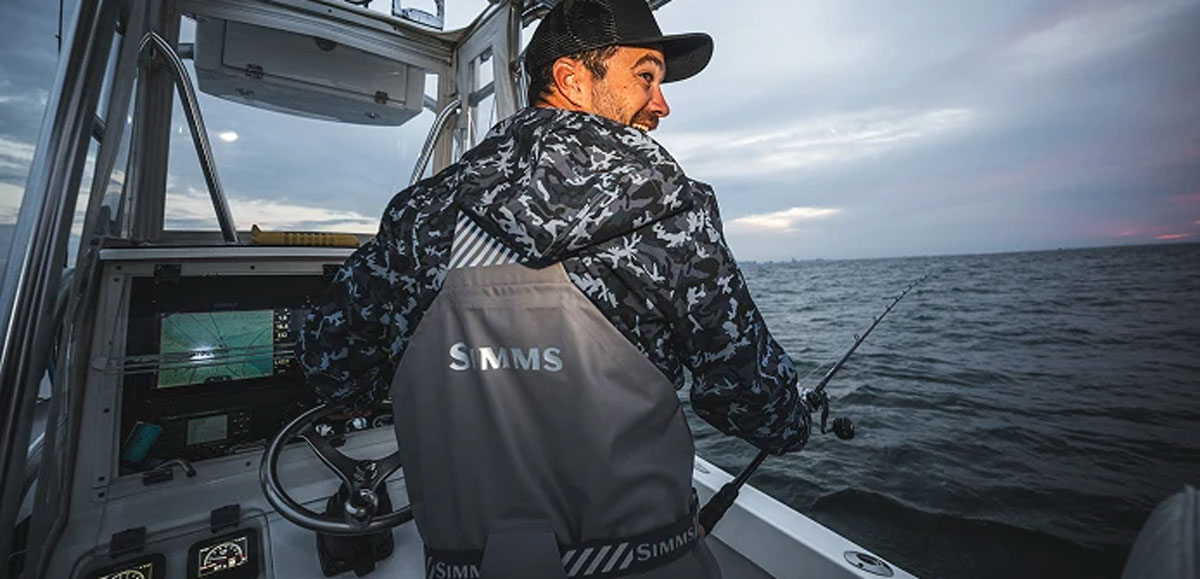 a captain wearing Simms Rip Line Pro on grey