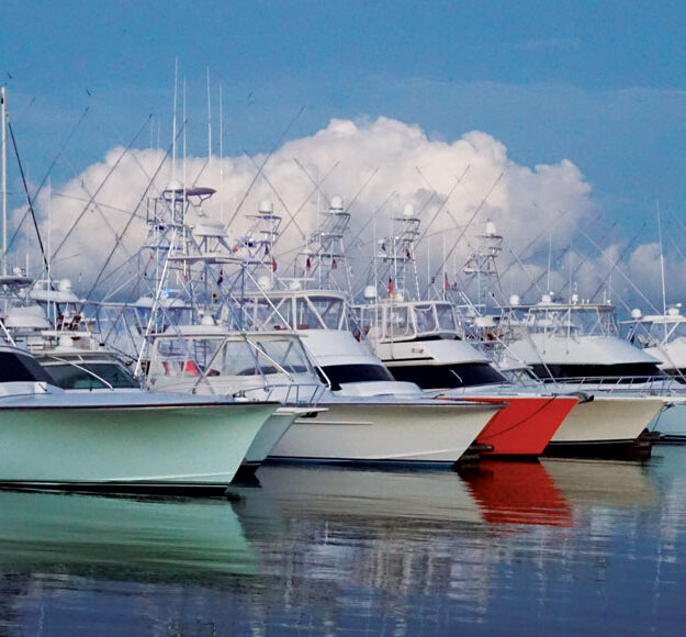 multi color sportfishing boat hulls reflecting on the water