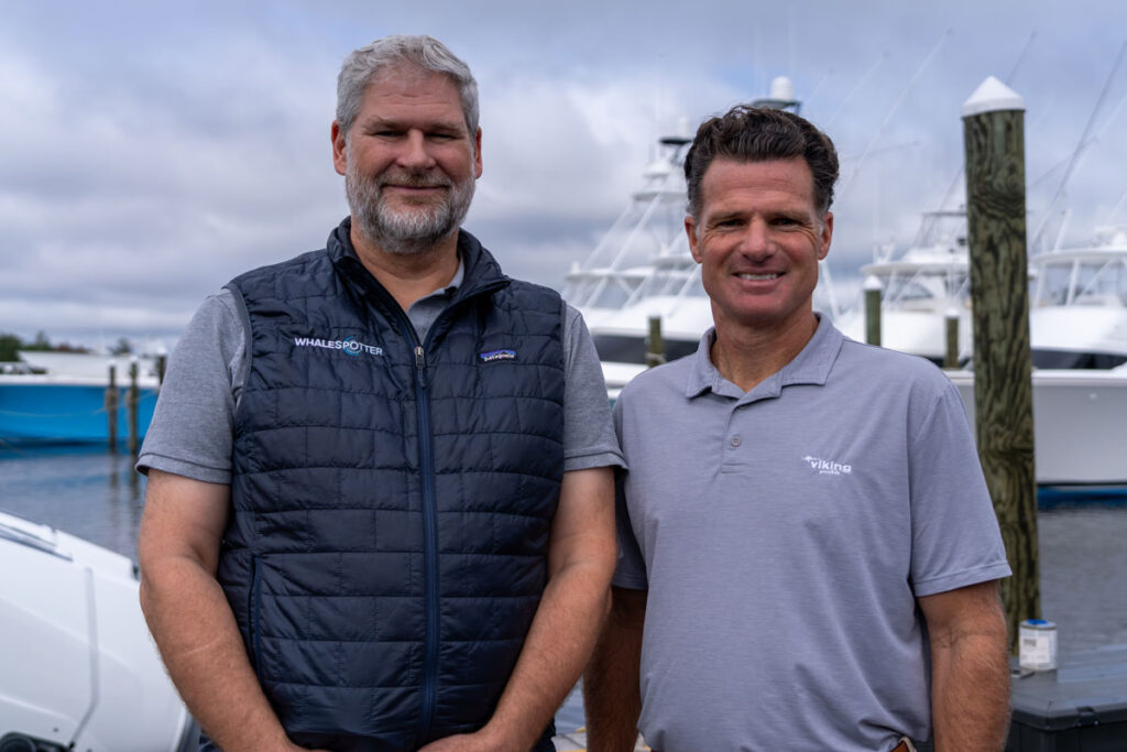 WhaleSpotter CEO Shawn Henry and Viking’s John DePersenaire standing on a dock in front of Viking sportfishing yachts.